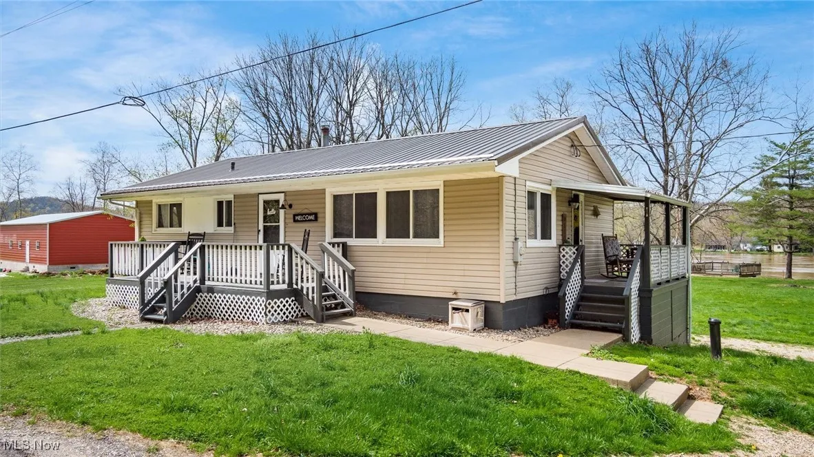 View of front of property featuring metal roof, crawl space, a front lawn, and covered porch