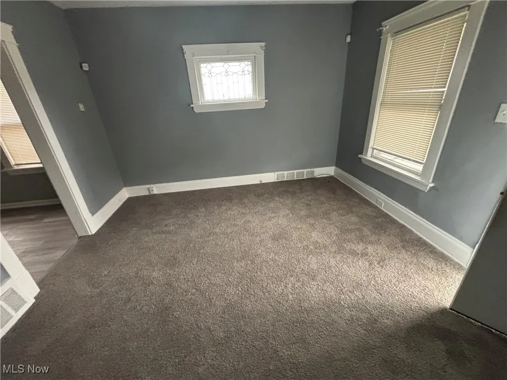 Unfurnished bedroom with carpet flooring, visible vents, and baseboards