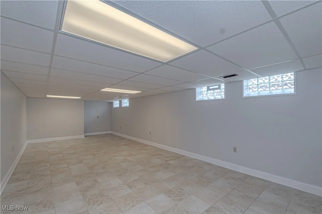 Below grade area featuring baseboards and a paneled ceiling