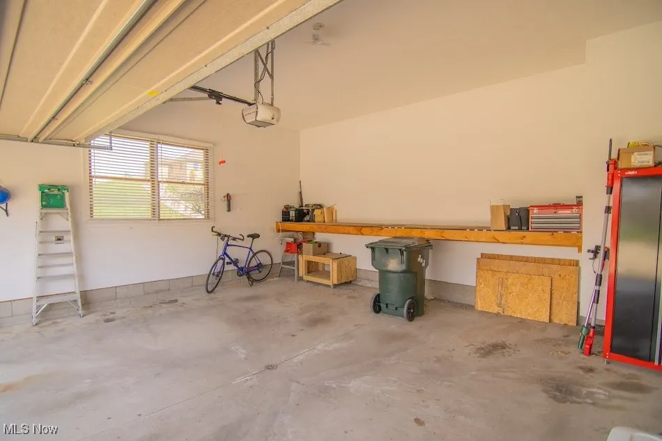 Garage featuring a garage door opener and a workshop area