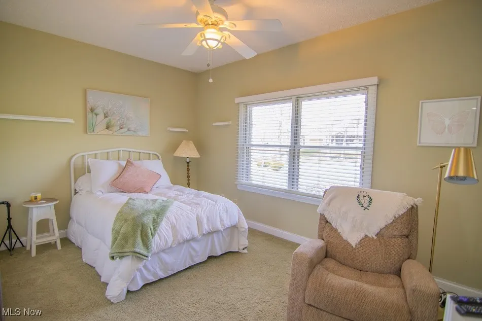 Bedroom featuring baseboards, a ceiling fan, and carpet flooring