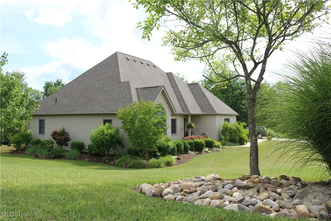 View of property exterior featuring a yard and roof with shingles