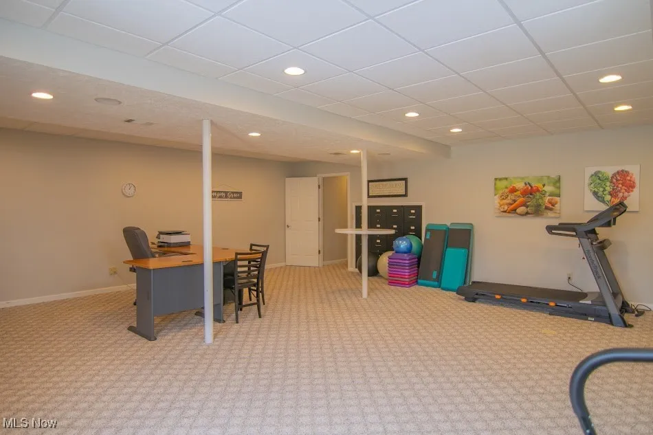 Carpeted office with a paneled ceiling, baseboards, and recessed lighting
