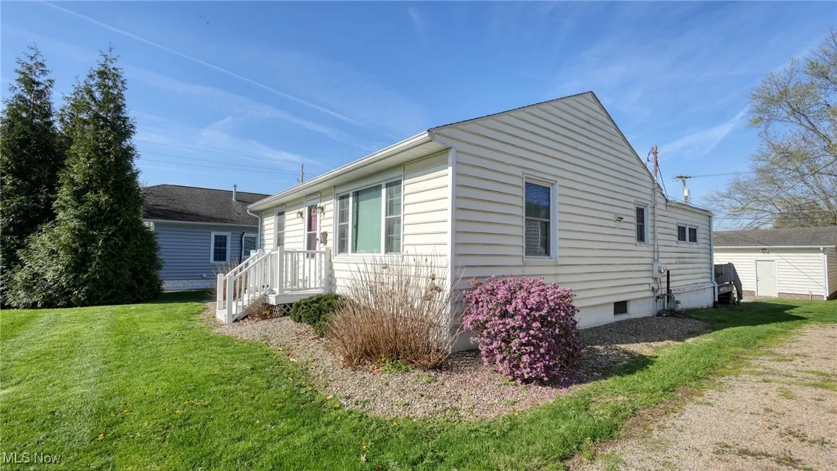 View of side of home featuring crawl space and a lawn