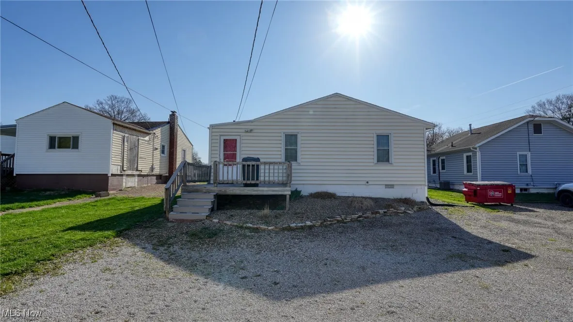 Side of property featuring crawl space and a wooden deck