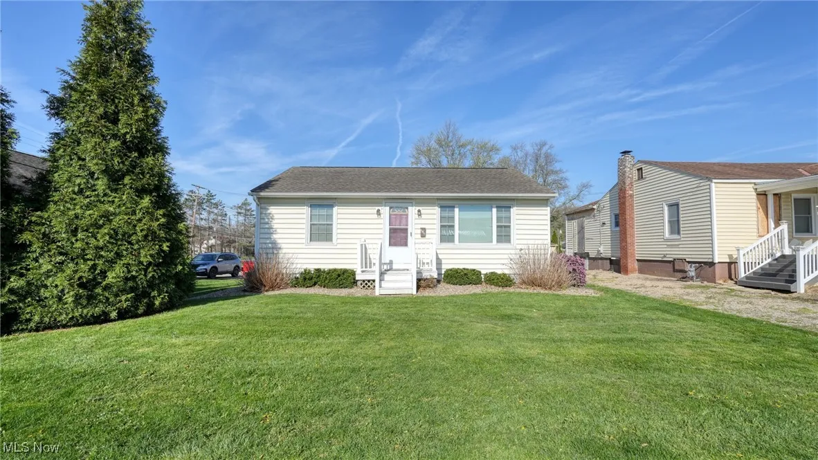 View of front of property with a shingled roof and a front lawn