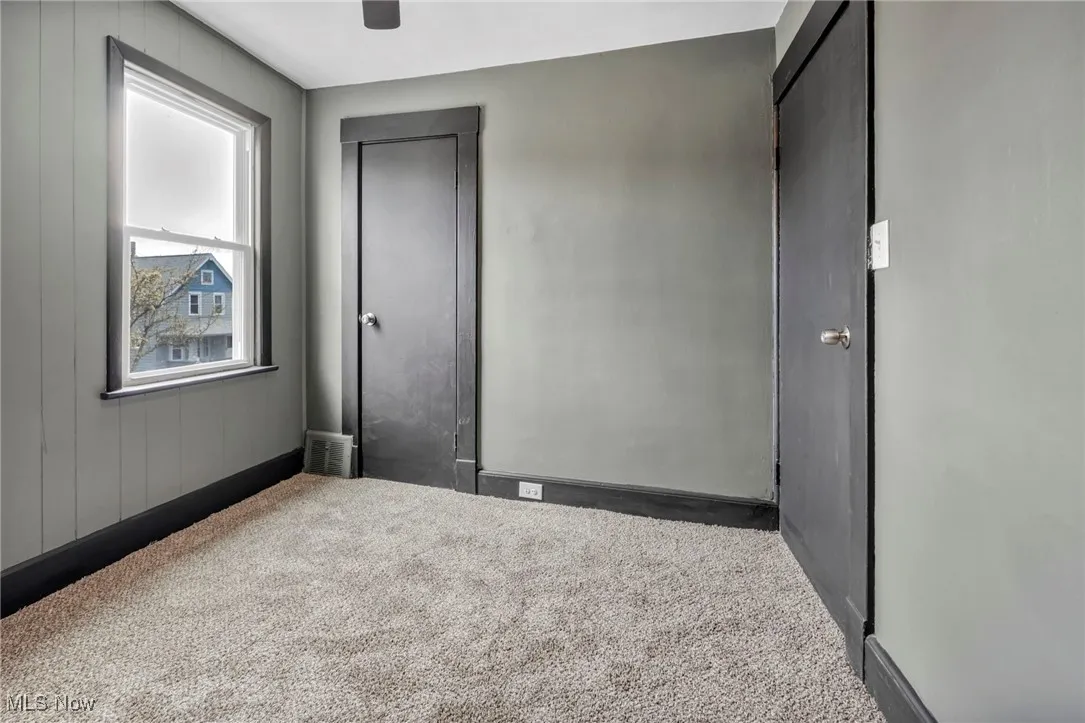 Unfurnished bedroom with carpet floors, ceiling fan, and visible vents