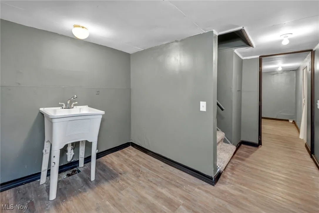 Laundry area with wood finished floors and baseboards
