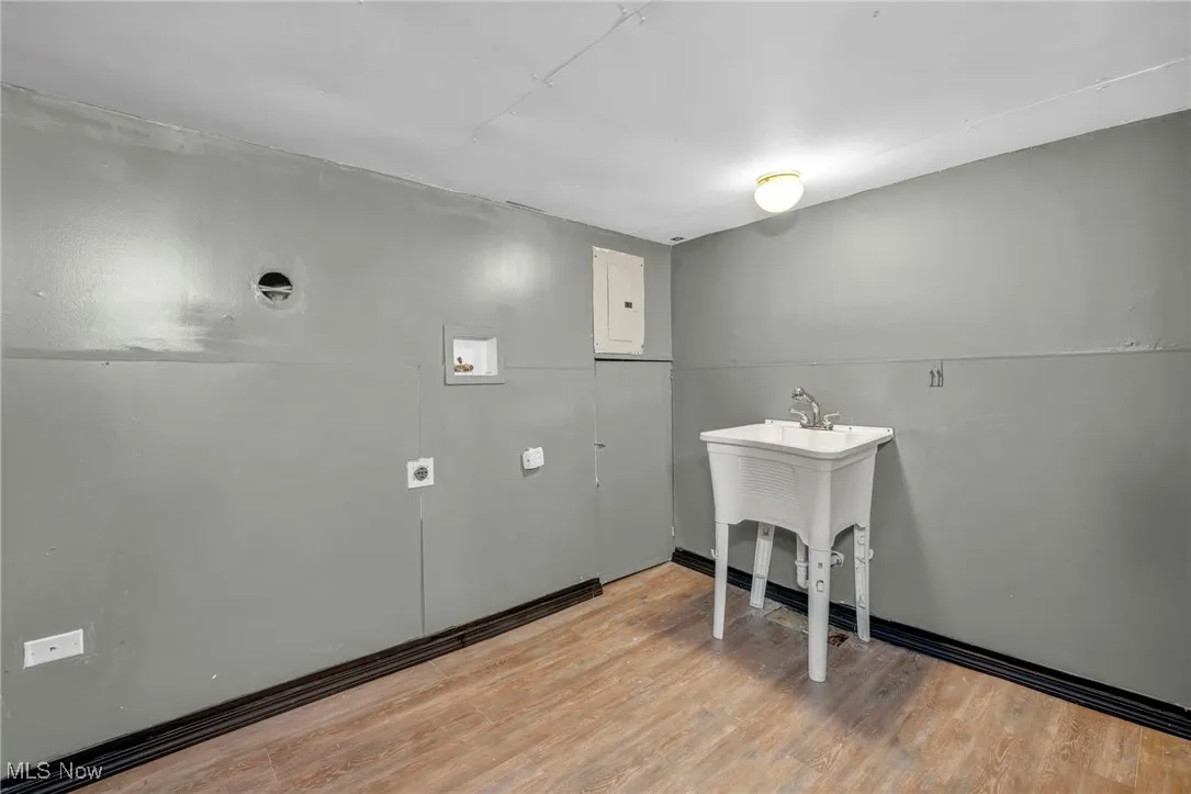 Washroom featuring washer hookup, light wood finished floors, laundry area, and electric panel