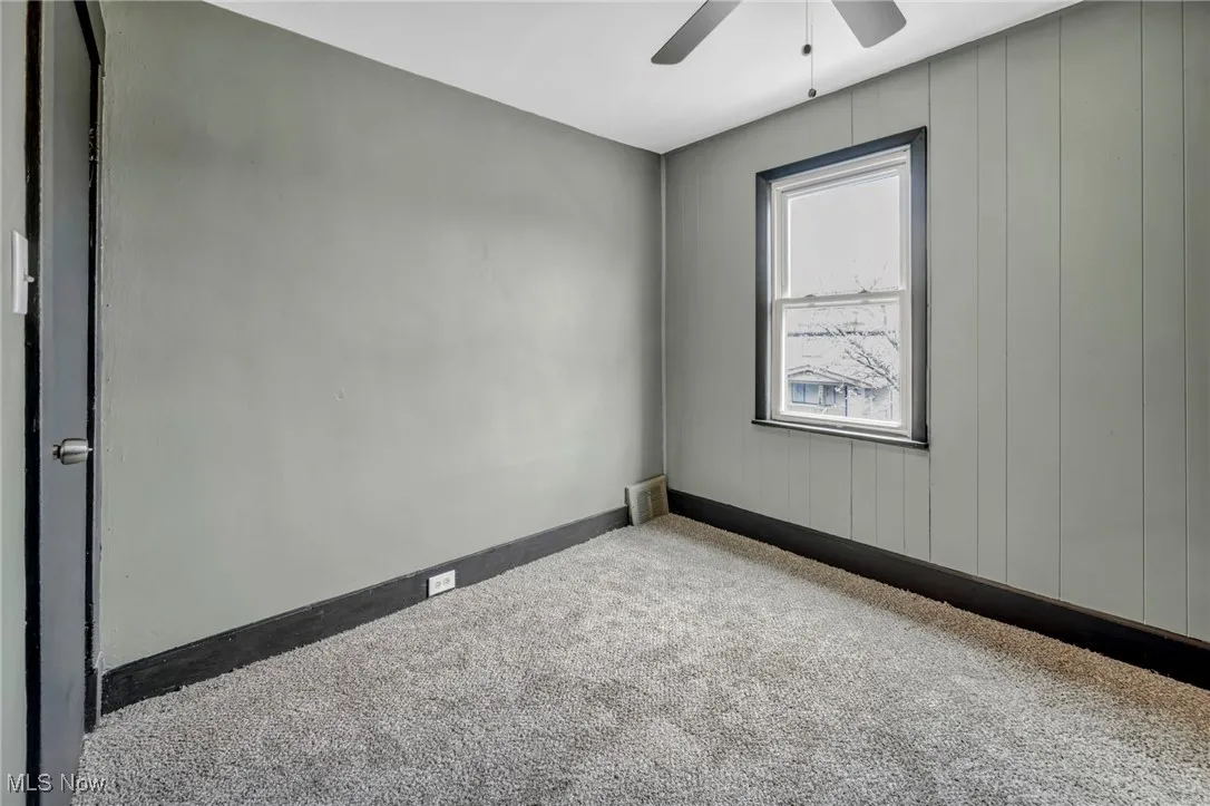 Carpeted empty room featuring visible vents, baseboards, and ceiling fan