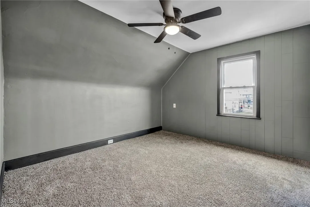 Additional living space featuring a ceiling fan, carpet flooring, and vaulted ceiling