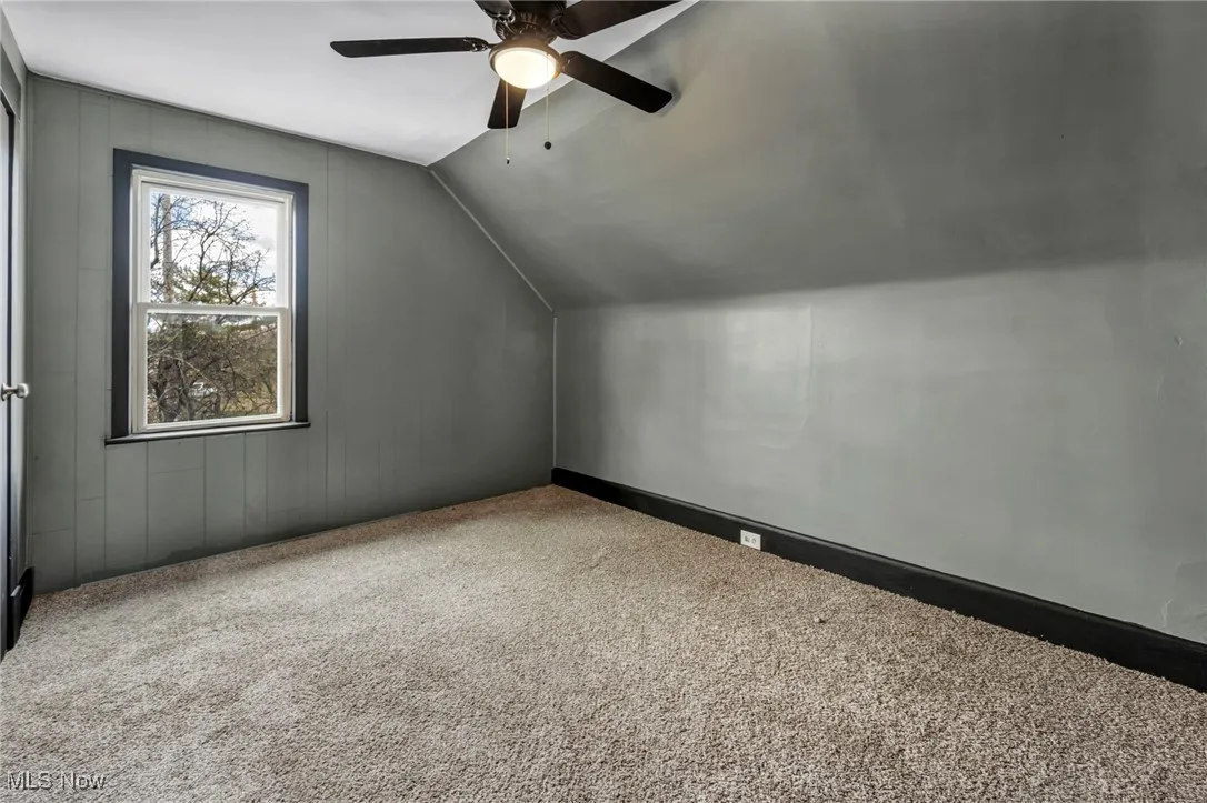 Bonus room with carpet floors, ceiling fan, and vaulted ceiling