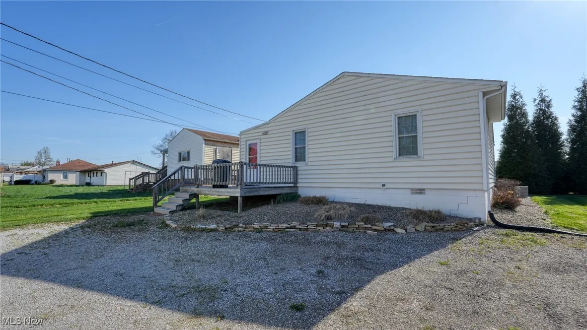 View of property exterior featuring crawl space and a wooden deck