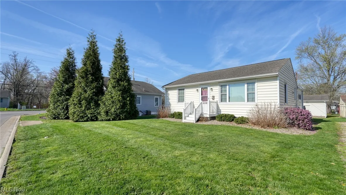 View of front of house featuring a front lawn and roof with shingles