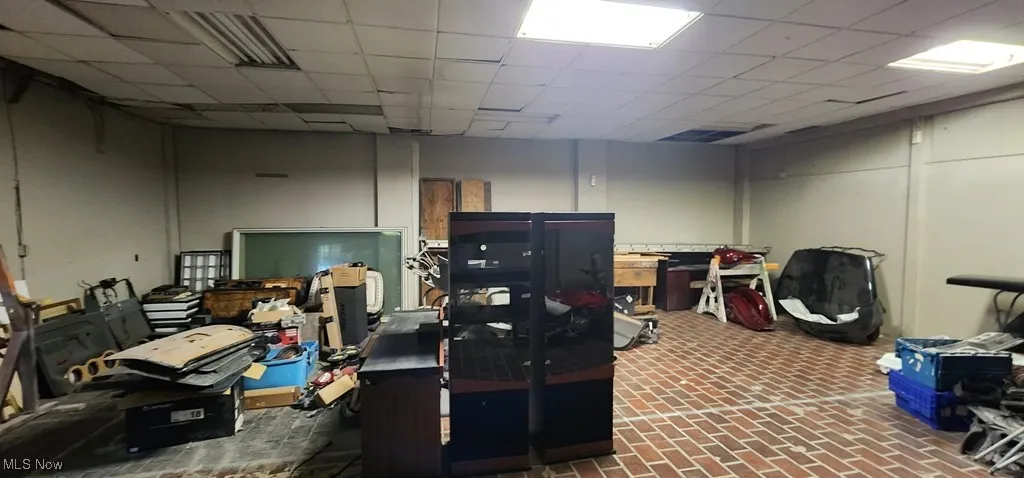 Below grade area featuring brick floor and a drop ceiling