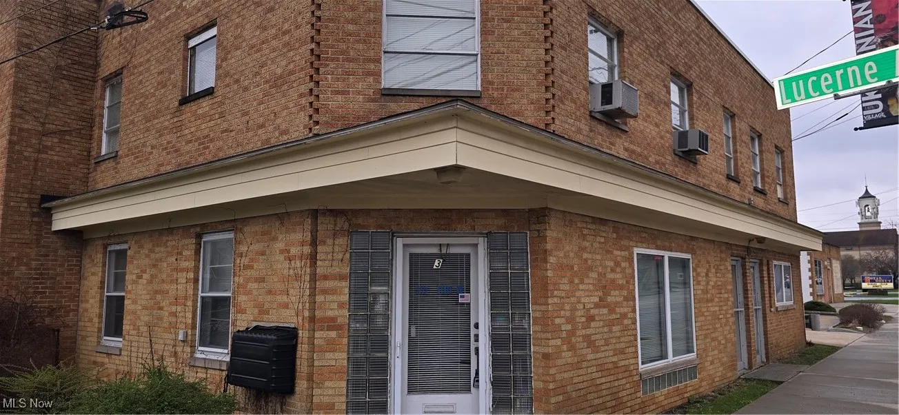 View of property exterior with brick siding and cooling unit