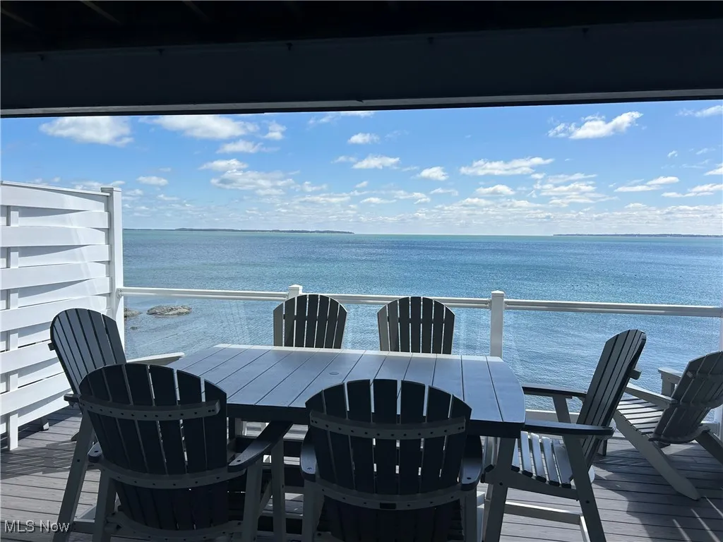 Deck featuring outdoor dining space and a water view