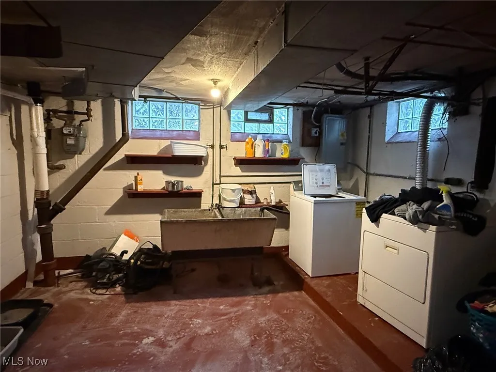 Basement with a sink and washing machine and clothes dryer