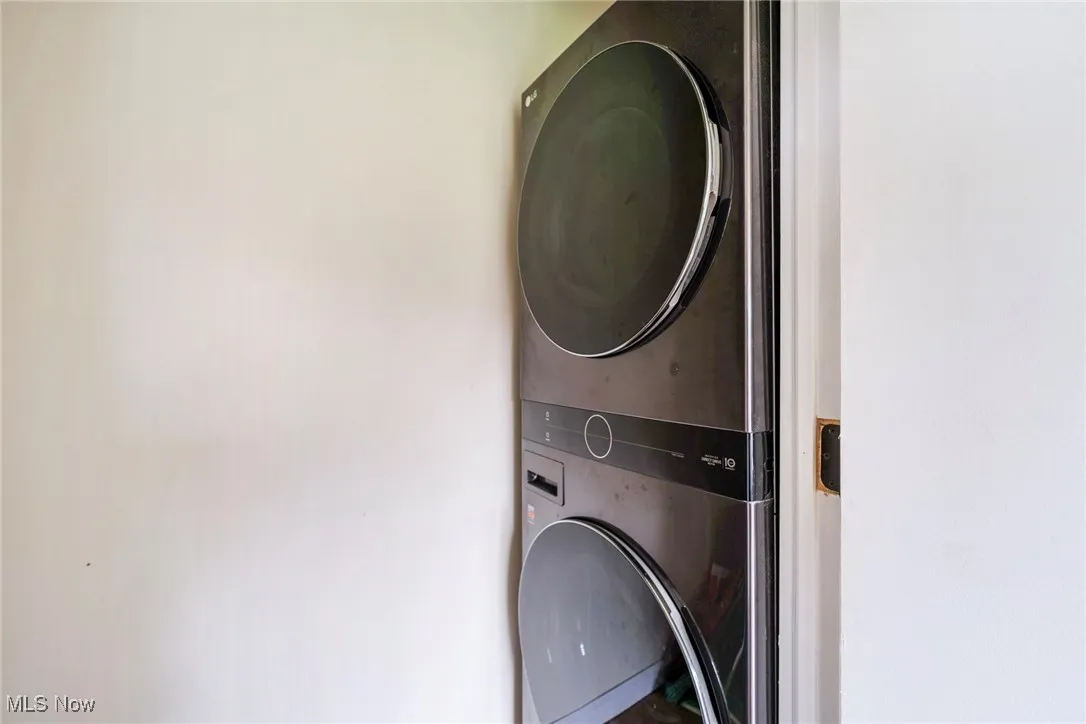 Washroom with stacked washer and dryer and laundry area