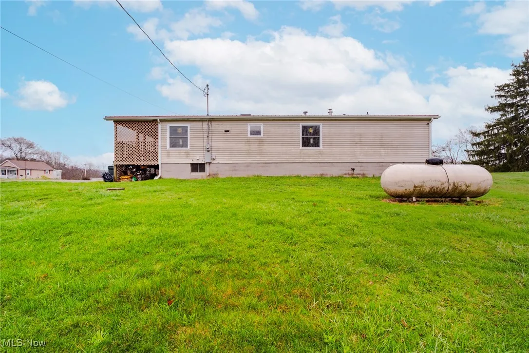 Rear view of house featuring a lawn
