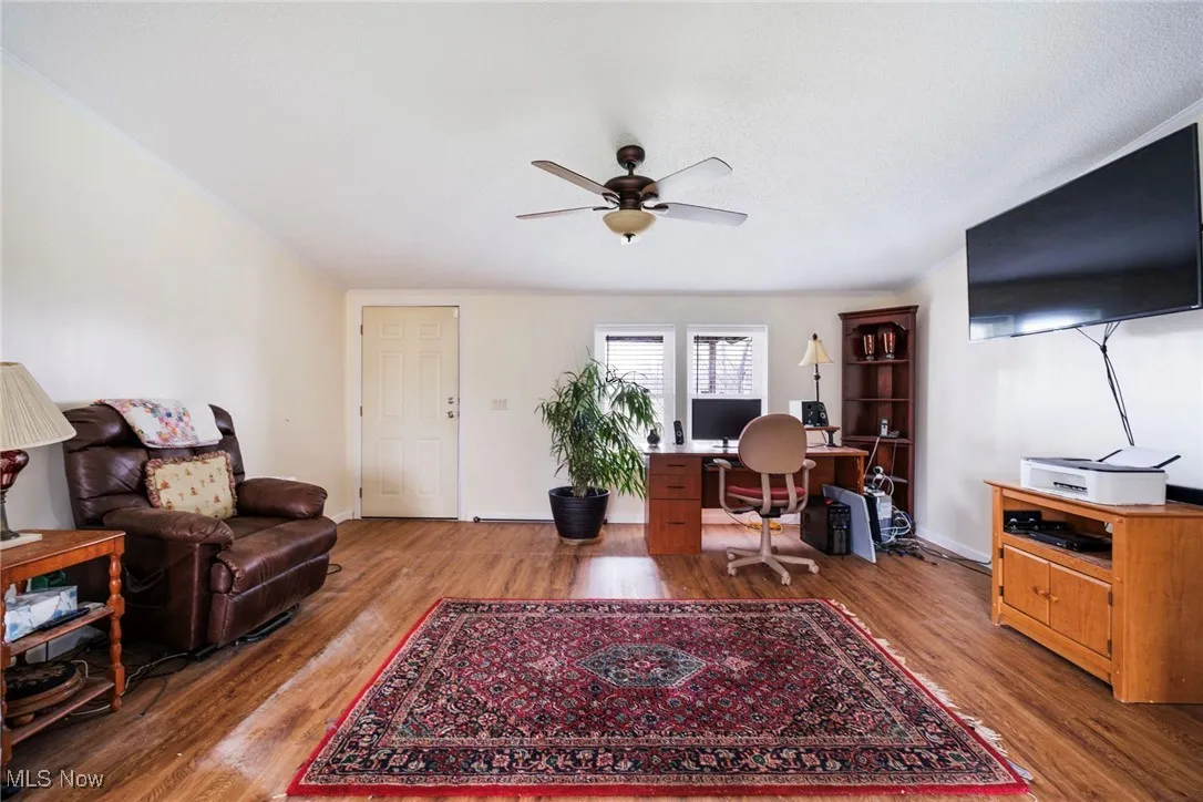 Living room with baseboards, a ceiling fan, and wood finished floors