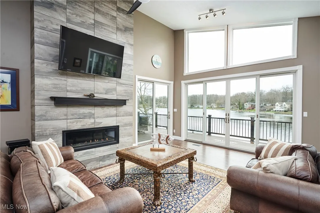 Living area with a fireplace, a high ceiling, baseboards, and wood finished floors