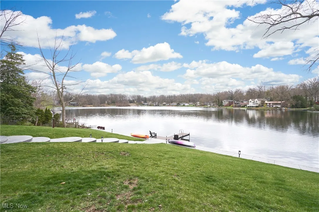 Dock area with a water view and a lawn
