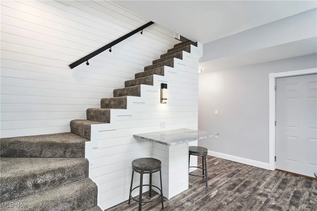 Staircase with wood finished floors and baseboards