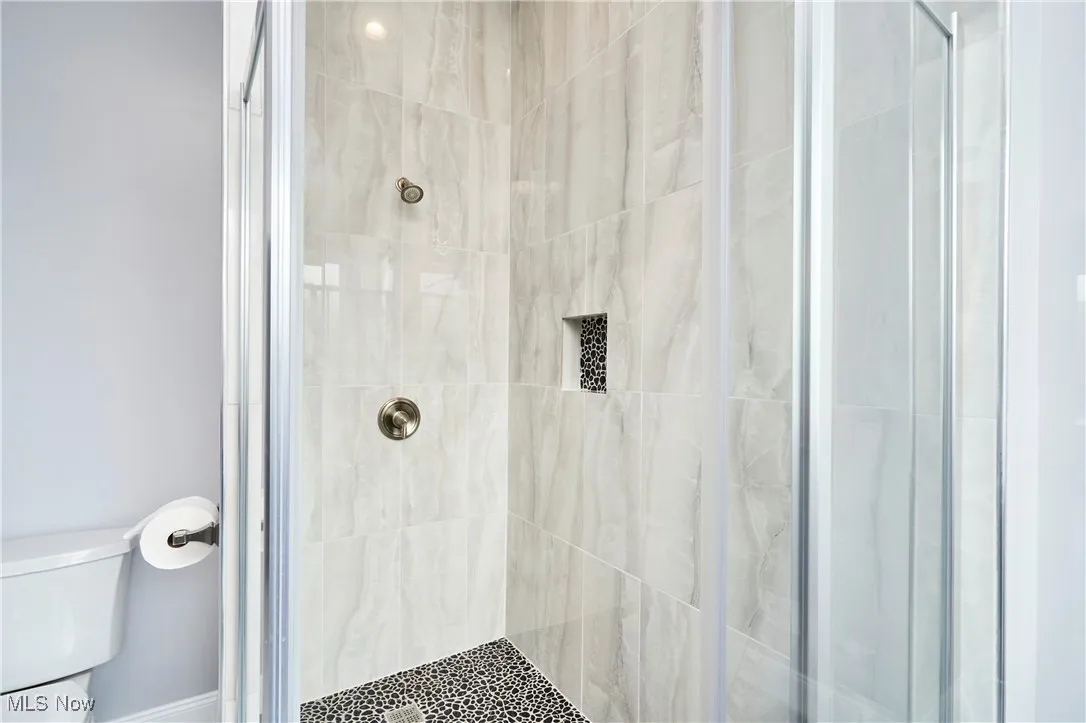 Bathroom featuring toilet and a stall shower