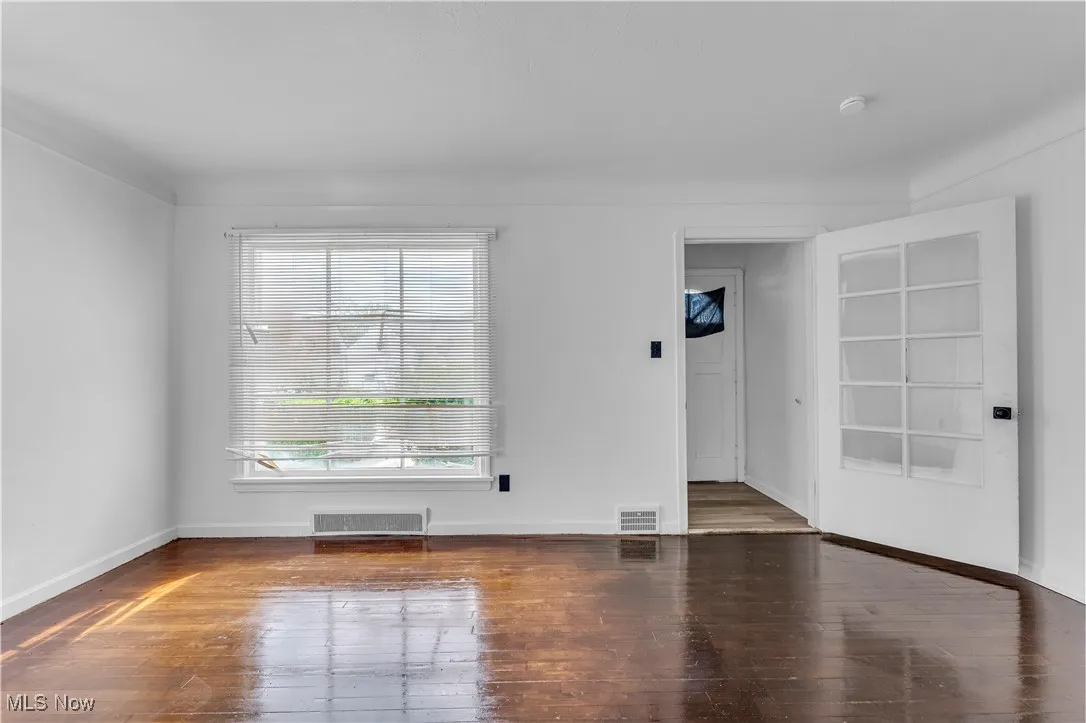 Unfurnished room featuring hardwood / wood-style floors and baseboards