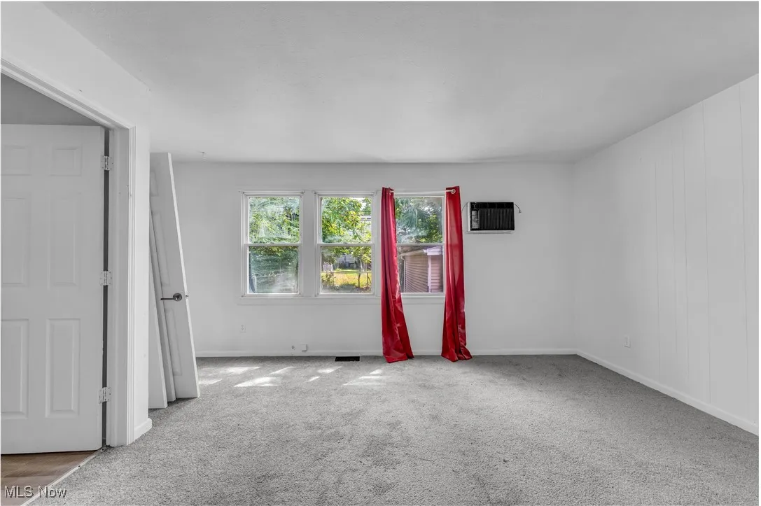 Spare room featuring carpet floors and a wall mounted air conditioner