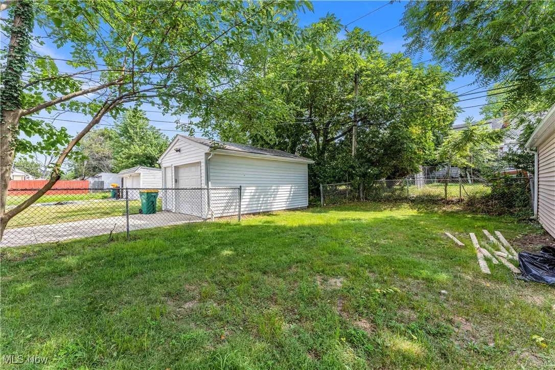 Fenced backyard with a garage and an outdoor structure