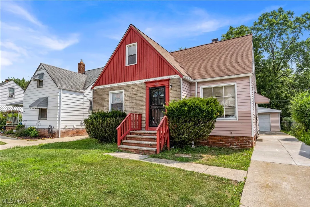 Bungalow-style house featuring a front lawn, roof with shingles, and an outbuilding