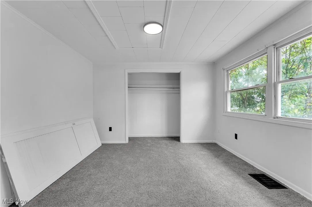 Unfurnished bedroom with carpet flooring and a closet