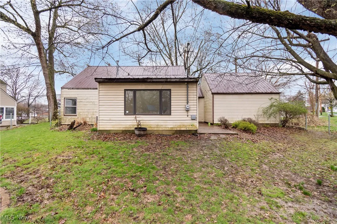 Back of property with a yard and metal roof