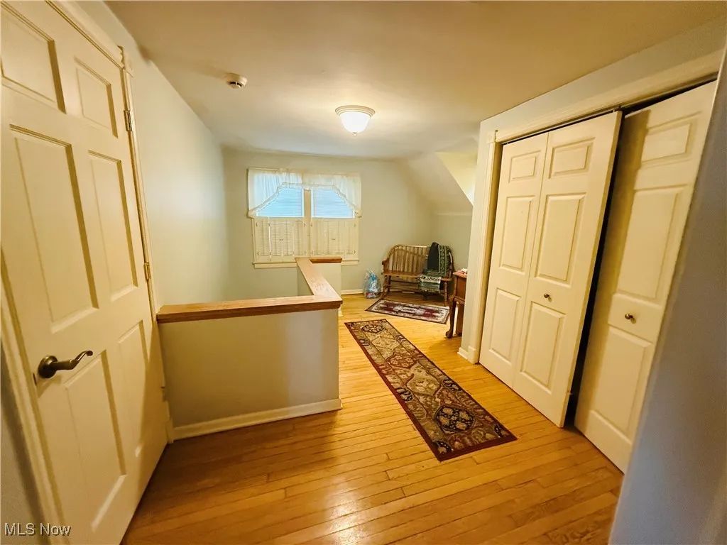 Bonus room featuring baseboards, light wood finished floors, and lofted ceiling