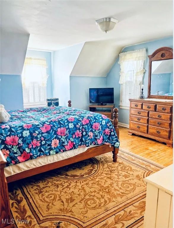 Bedroom with vaulted ceiling and wood finished floors