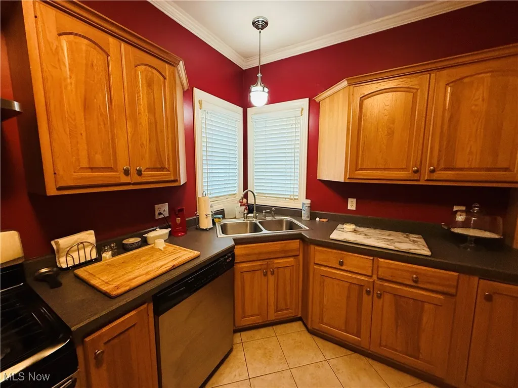 Kitchen with dark countertops, brown cabinets, a sink, and stainless steel appliances