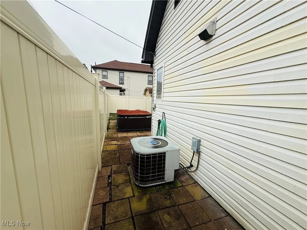 View of home's exterior with a patio area, central AC unit, and fence