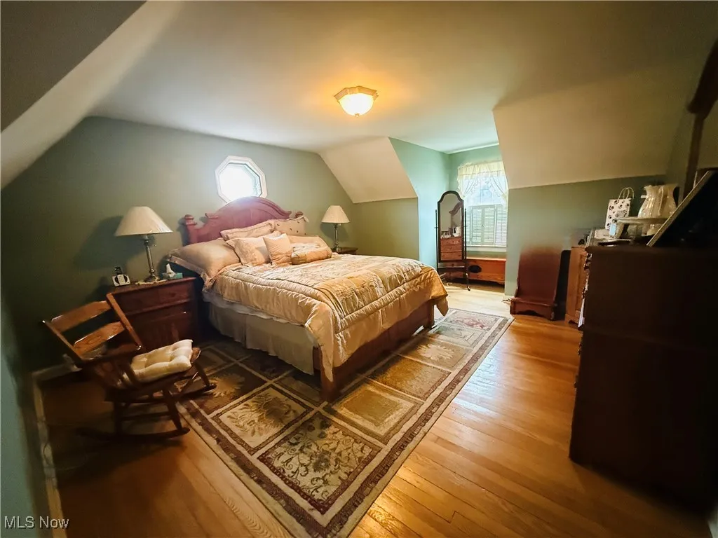 Bedroom featuring wood finished floors and lofted ceiling