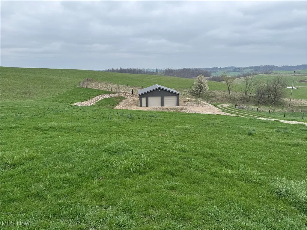 View of yard featuring a rural view and an outdoor structure