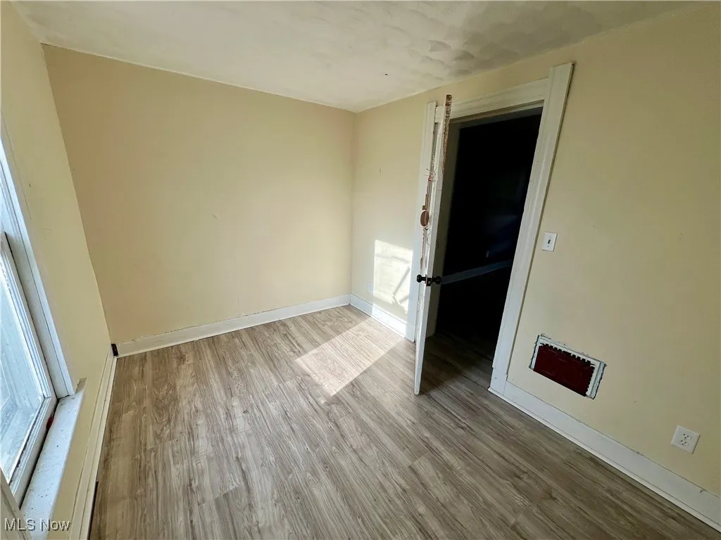 Empty room featuring baseboards and wood finished floors