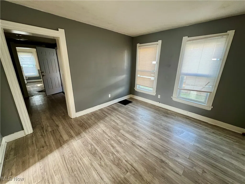 Unfurnished room featuring baseboards and wood finished floors
