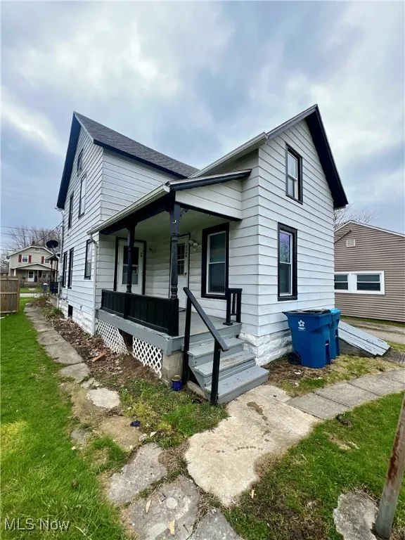View of front of house with a front yard and a porch