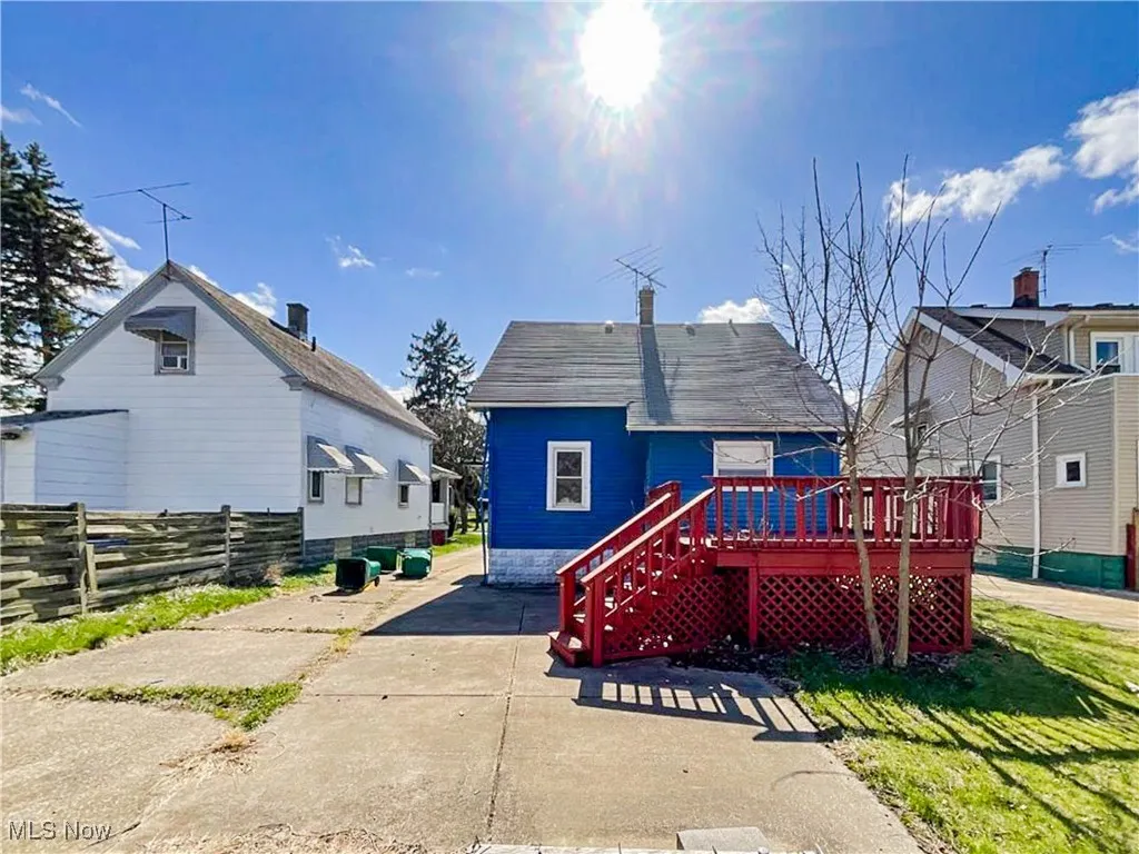 Back of property with a deck and fence