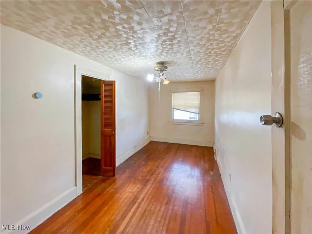 Unfurnished room with baseboards and wood finished floors