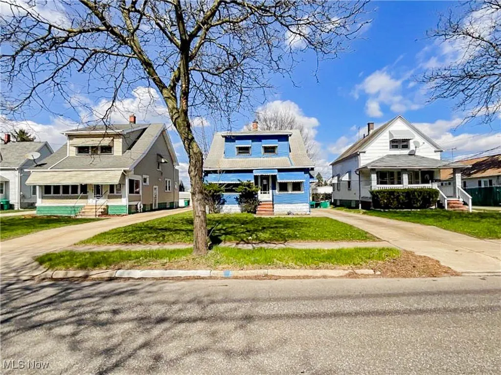 Bungalow-style home featuring a porch, a chimney, driveway, and a front lawn