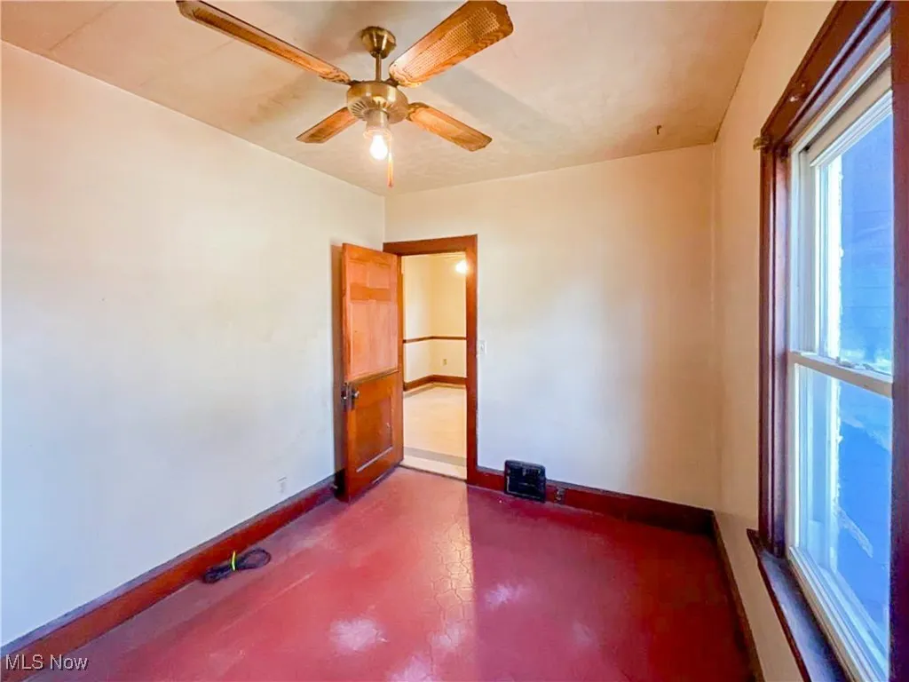 Empty room featuring baseboards and ceiling fan