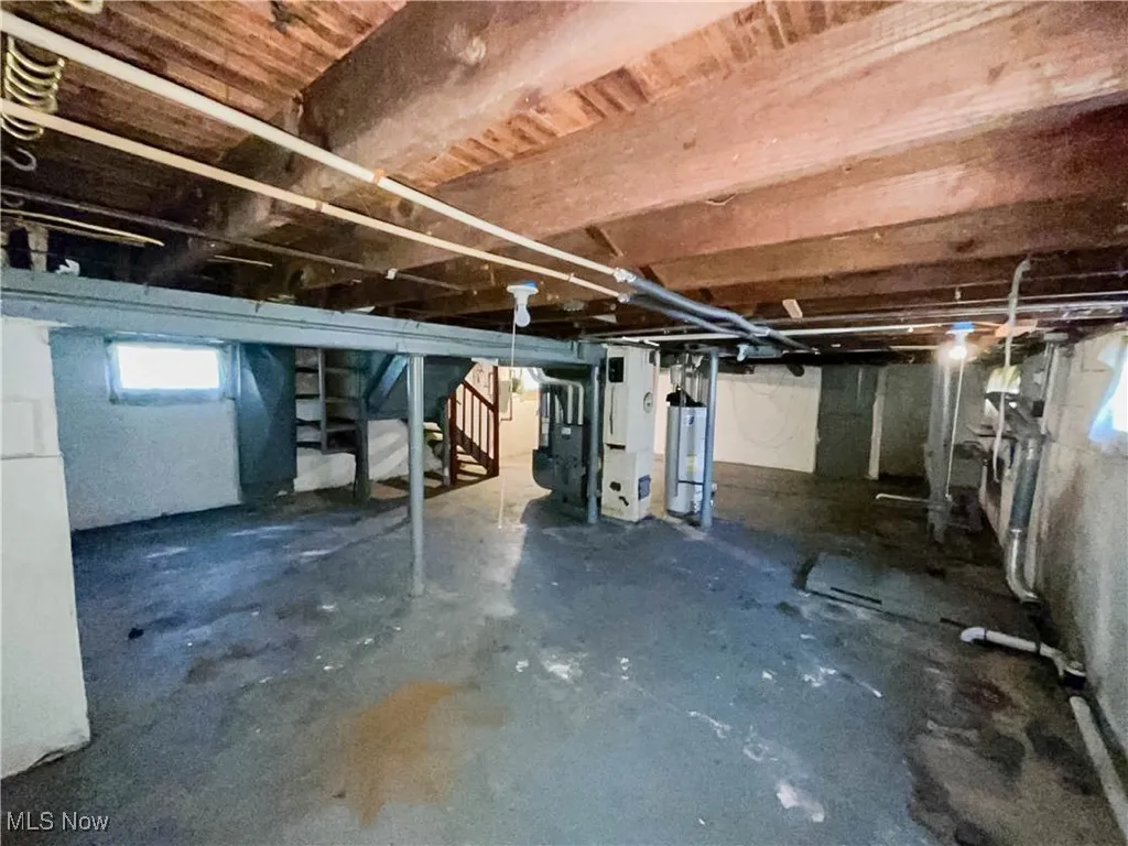 Basement featuring stairway and gas water heater