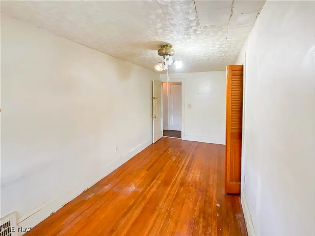 Empty room featuring visible vents, hardwood / wood-style flooring, and baseboards